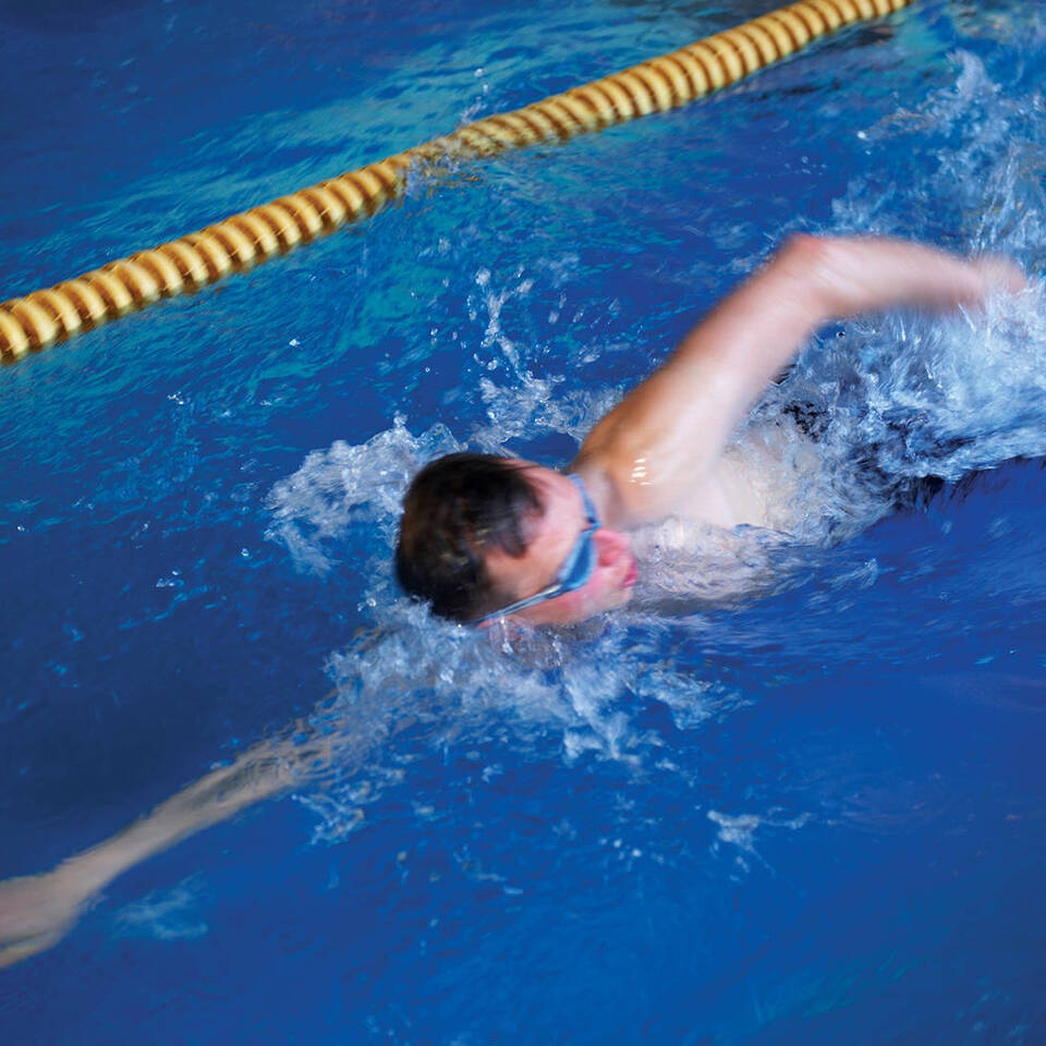 A male swimmer swimming lengths of Benton Hall's swimming pool